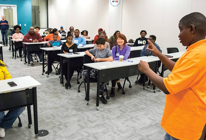 Kid speaking in front of a room full of people