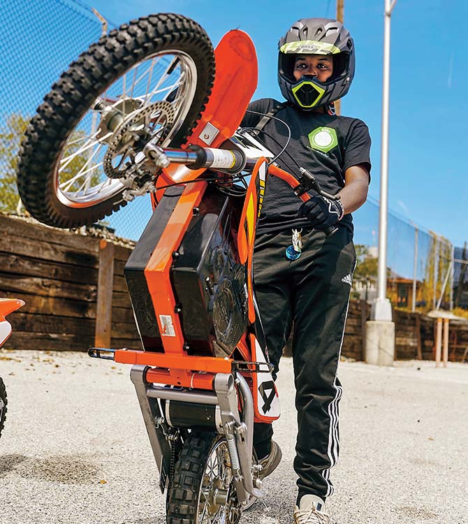 Person wearing a helmet and showing off their dirt bike