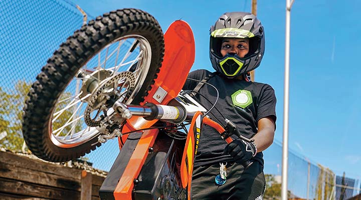 Person wearing a helmet and showing off their dirt bike