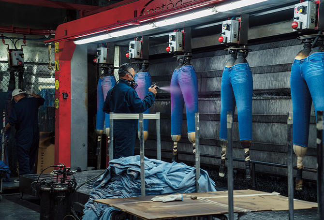 Photo of a person spraying painting jeans