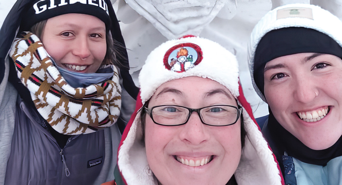 Photo of three people in warm clothing taking a selfie together
